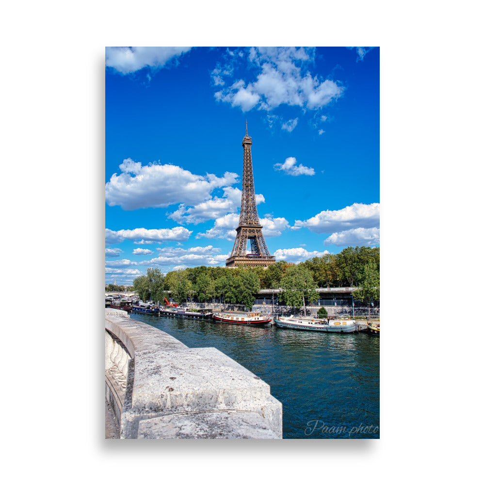 Vue panoramique de la Tour Eiffel et des péniches sur la Seine, sous un ciel bleu nuageux – une œuvre signée Antony Porlier.