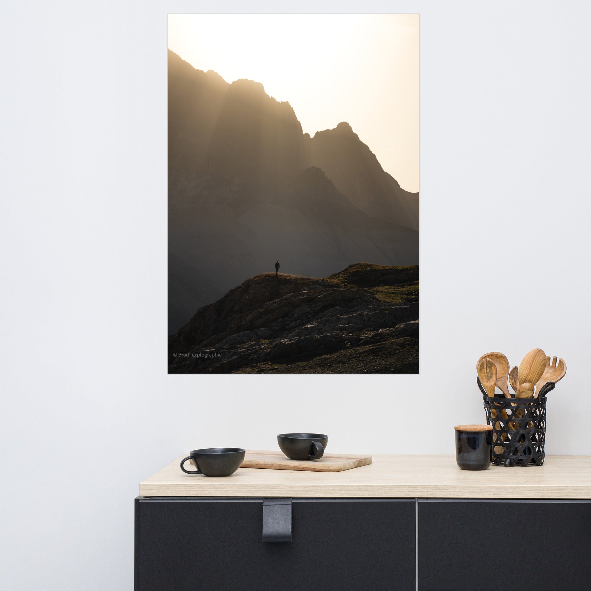 Vue panoramique des montagnes au coucher du soleil, où la lumière dorée enveloppe les pics et les vallées – une œuvre signée par Brad_explographie.