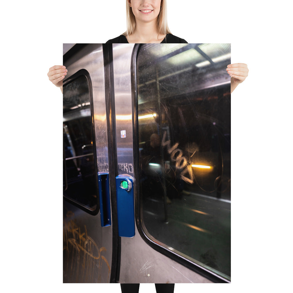 Poster 'Métro' représentant une porte de métro usée et des passants flous, capturé depuis un wagon en mouvement.