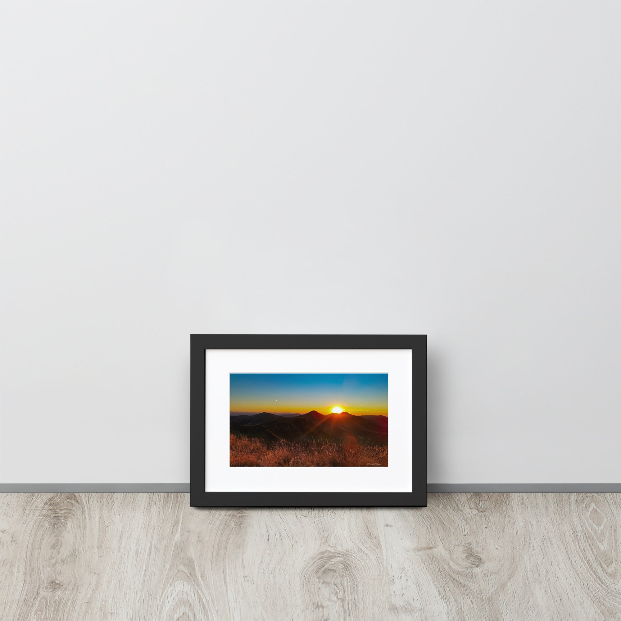 Poster encadré 'Coucher d'été' montrant un paysage montagneux du Cantal au coucher du soleil, avec des sommets silhouettés sous un ciel rougeoyant, signé par Math Shoot Fr.
