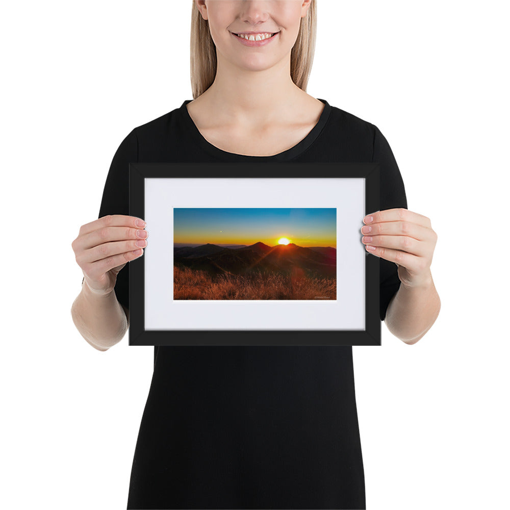 Poster encadré 'Coucher d'été' montrant un paysage montagneux du Cantal au coucher du soleil, avec des sommets silhouettés sous un ciel rougeoyant, signé par Math Shoot Fr.