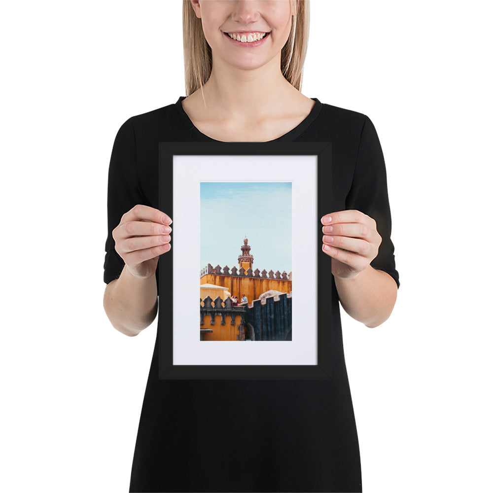 Photographie argentique 'Palais National de Pena' par Benjamin Peccard, représentant les murs orangés et patinés du palais historique sous la pluie, avec trois touristes semblant minuscules face à sa stature imposante, offrant une perspective élégante et historique pour la décoration murale.