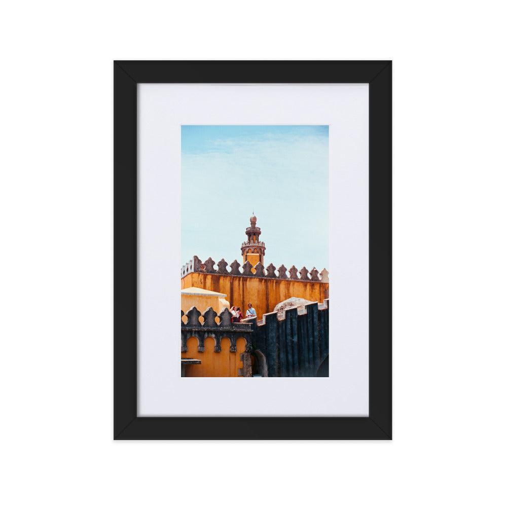 Photographie argentique 'Palais National de Pena' par Benjamin Peccard, représentant les murs orangés et patinés du palais historique sous la pluie, avec trois touristes semblant minuscules face à sa stature imposante, offrant une perspective élégante et historique pour la décoration murale.