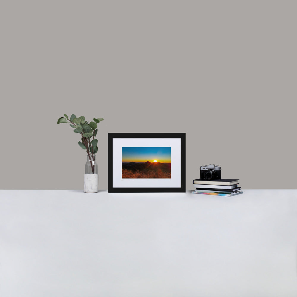 Poster encadré 'Coucher d'été' montrant un paysage montagneux du Cantal au coucher du soleil, avec des sommets silhouettés sous un ciel rougeoyant, signé par Math Shoot Fr.