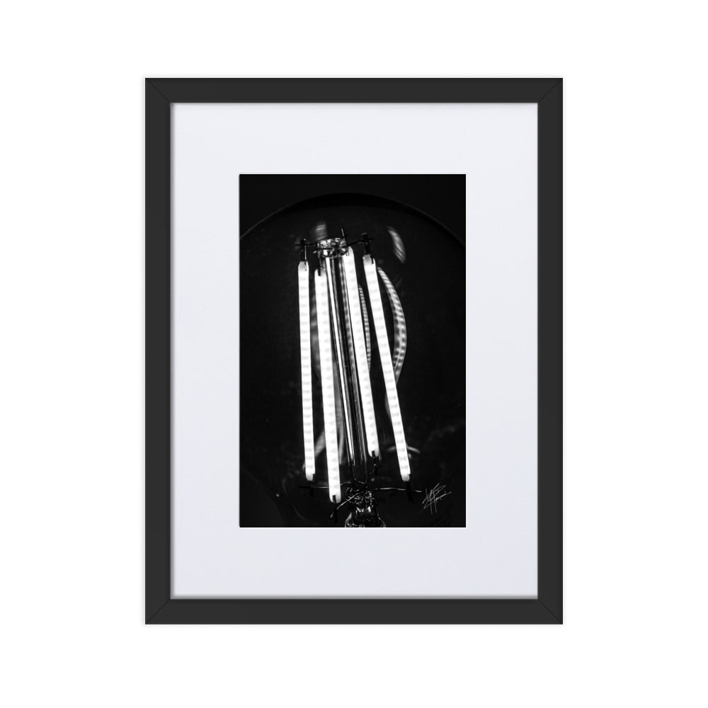 Photographie en gros plan d'une ampoule allumée en noir et blanc, où les filaments brillent de manière éclatante sur un fond sombre, encapsulant la beauté dans la simplicité.