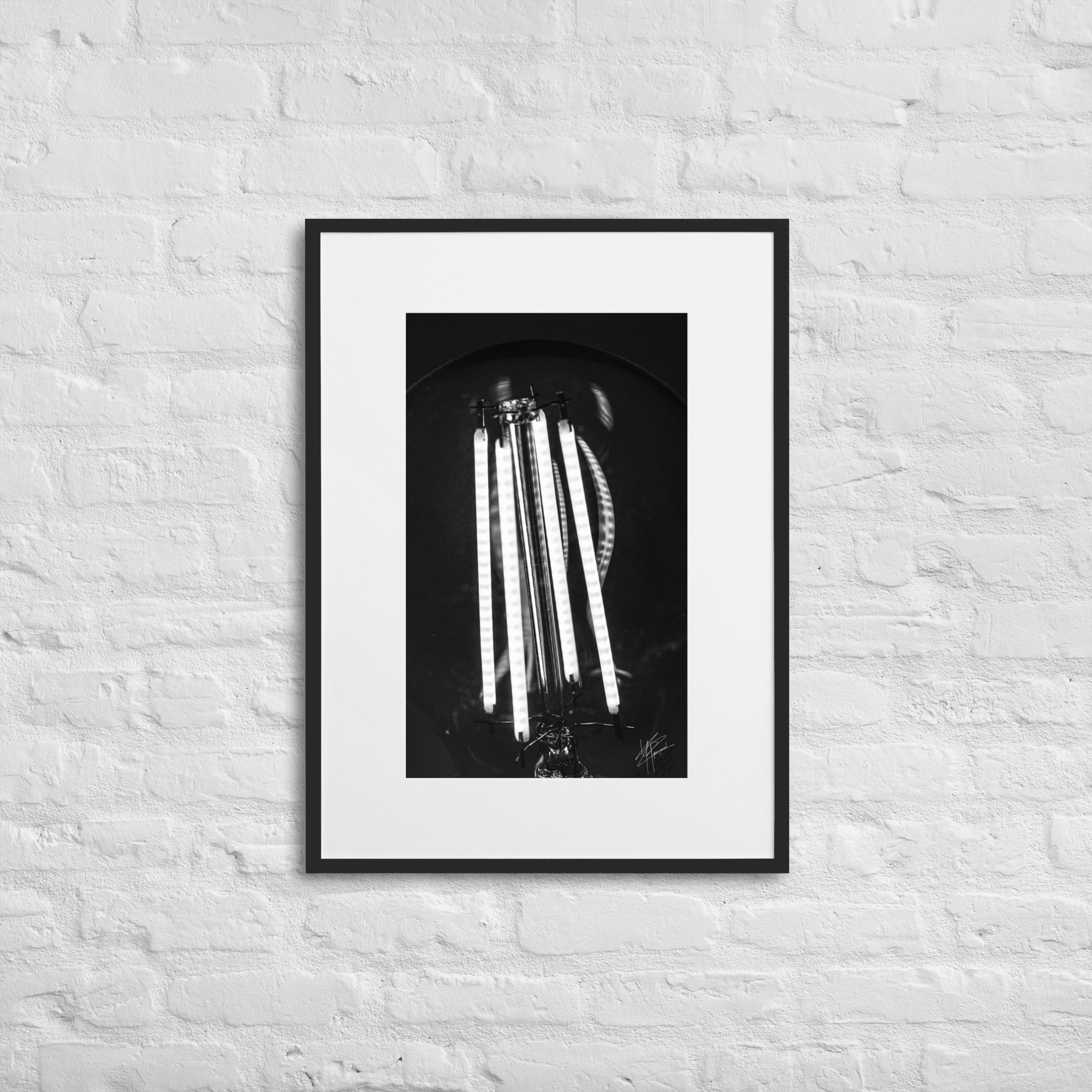 Photographie en gros plan d'une ampoule allumée en noir et blanc, où les filaments brillent de manière éclatante sur un fond sombre, encapsulant la beauté dans la simplicité.