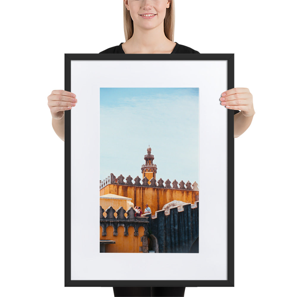 Photographie argentique 'Palais National de Pena' par Benjamin Peccard, représentant les murs orangés et patinés du palais historique sous la pluie, avec trois touristes semblant minuscules face à sa stature imposante, offrant une perspective élégante et historique pour la décoration murale.