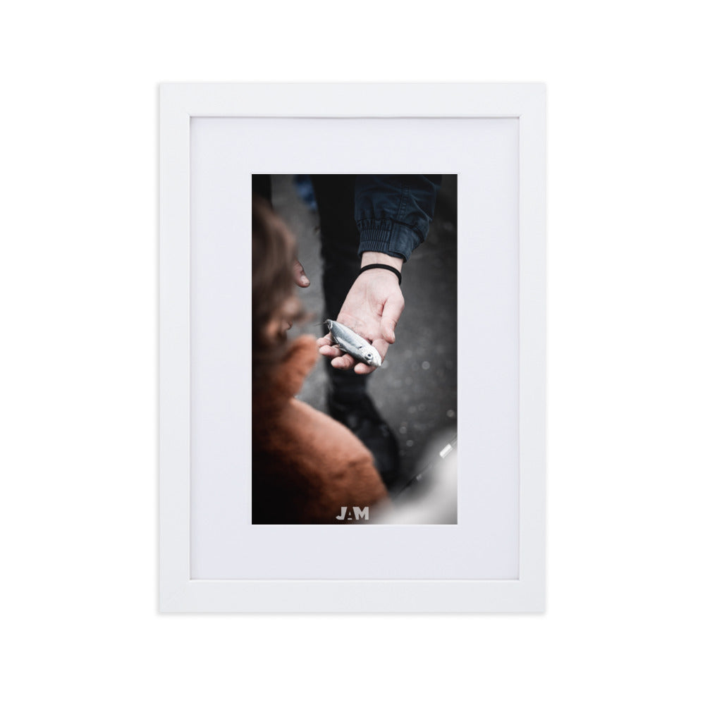 Photographie 'Prise du Jour : Une Connexion Éphémère' de Julien Arnold Movie, montrant une main humaine tenant délicatement un poisson, symbolisant la connexion fragile avec la nature.