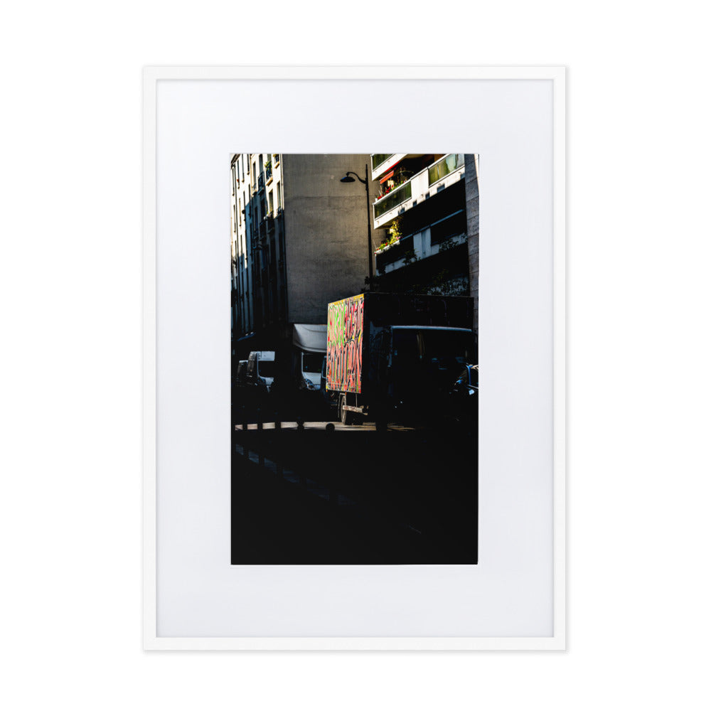 Poster La brèche - Une photographie abstraite d'un camion stationné dans une rue sombre de Paris, éclairé par un rayon de soleil.