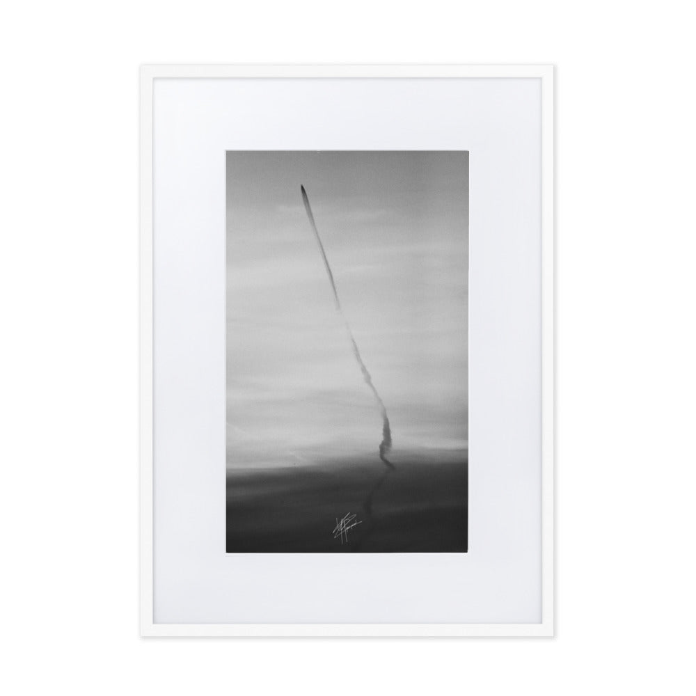 Photographie en noir et blanc du ciel avec des traces d'avions formant une longue ligne noire, encadrée d'un cadre en bois d'ayous blanc.